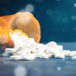 Addictive drugs spilling out of a prescription bottle