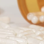 pill-bottle-spilling-white-capsule-pills-on-white