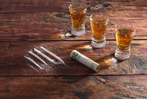 Cocaine and alcohol on a wooden table