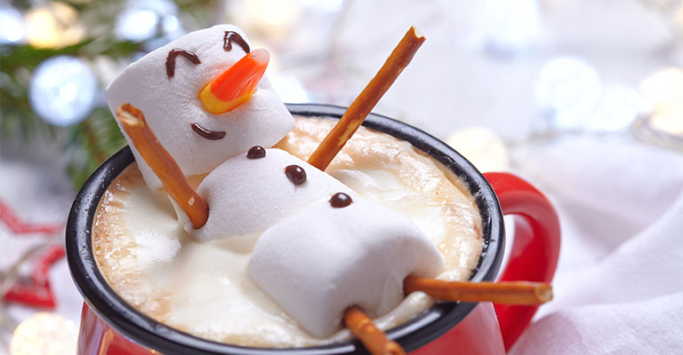 A marshmallow man in a cup of hot chocolate
