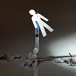 A paper figure stabbed with a syringe symbolizing heroin overdose