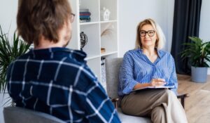 Professional psychotherapy. Female psychologist having session with male patient at mental health clinic, Taking Note During Appointment In Office. Psychological help service. Treatment of depression at Serenity at Summit New England