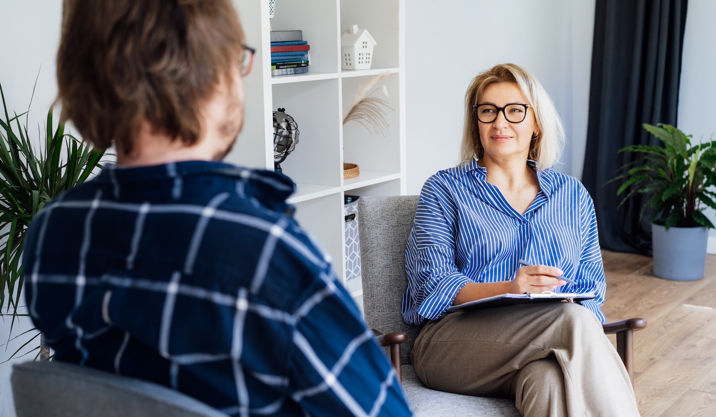Professional psychotherapy. Female psychologist having session with male patient at mental health clinic, Taking Note During Appointment In Office. Psychological help service. Treatment of depression at Serenity at Summit New England